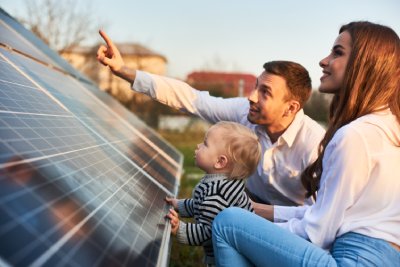Un papa expliquant à sa famille comment stocker l'électricité de leurs panneaux photovoltaïques 